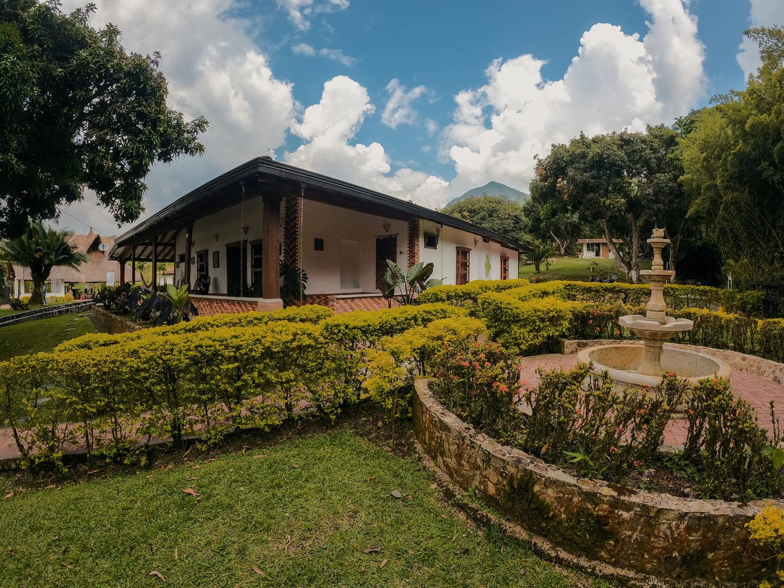 Casa principal del club con jardín y fuente