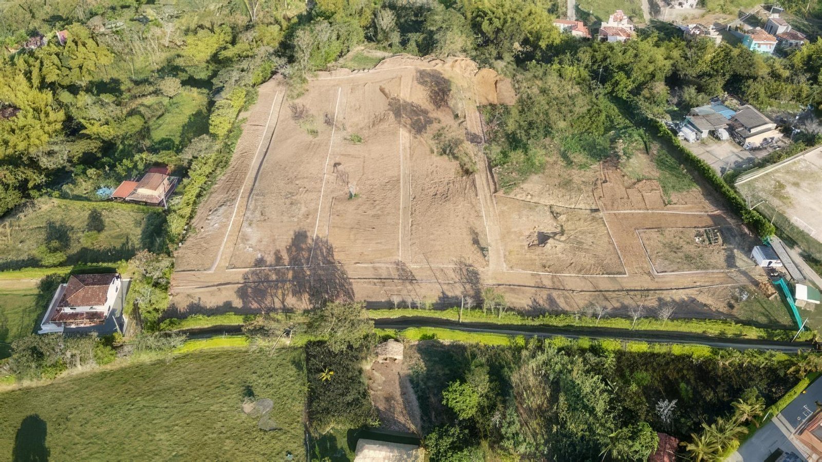 Vista aérea del lote del proyecto rodeado de vegetación